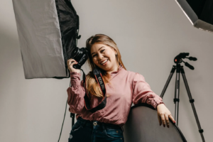 Fotógrafa com uma câmara num estúdio com equipamento de iluminação